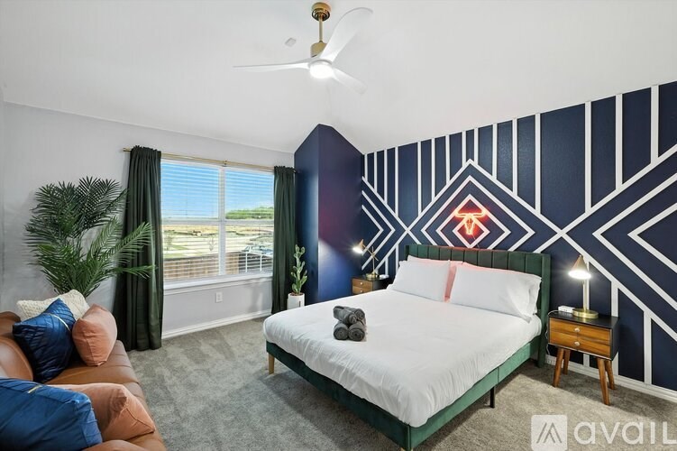 A bedroom with a bed, a couch, and a ceiling fan.