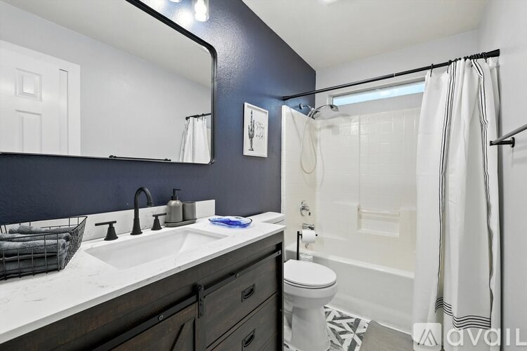 A bathroom with a white sink and a white toilet.