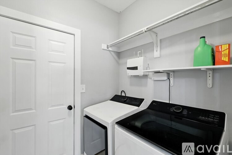 A small laundry room with a washer and dryer.
