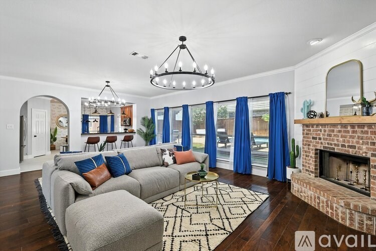 A living room with a grey sofa and a fireplace.