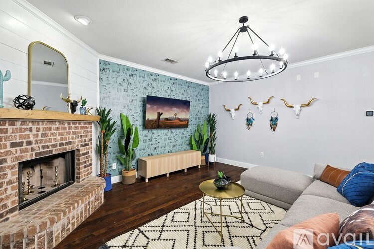 A living room with a brick fireplace and a flat screen TV mounted on the wall.