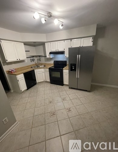 A kitchen with white cabinets and a black oven.