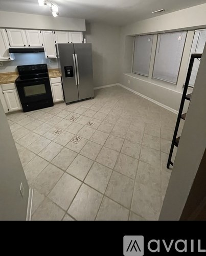 A kitchen with a black oven and a white fridge.