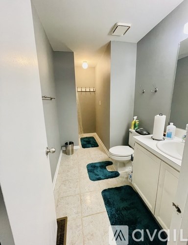 A bathroom with a toilet, sink, and mirror.