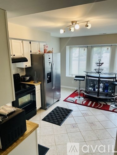 A kitchen with a refrigerator, microwave, and oven.