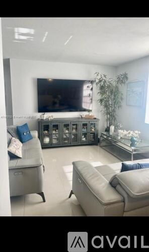 A living room with a grey sofa and a glass cabinet.