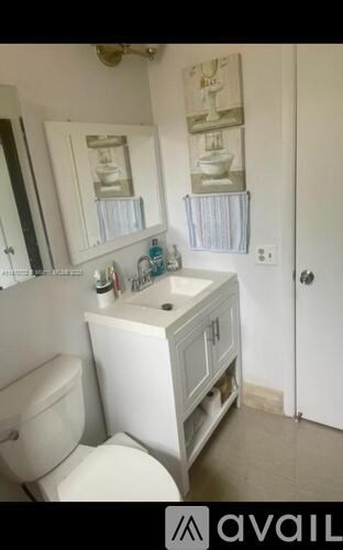 A bathroom with a toilet, sink, and mirror.