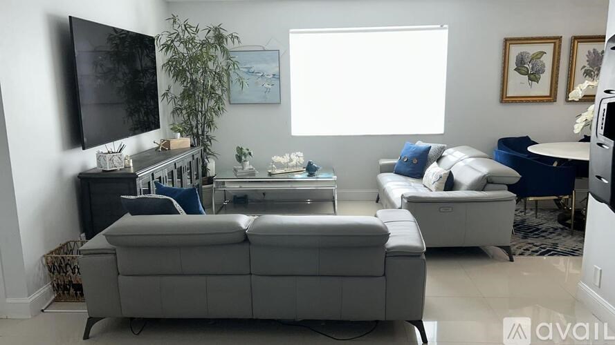 A living room with a grey sofa and a black television.