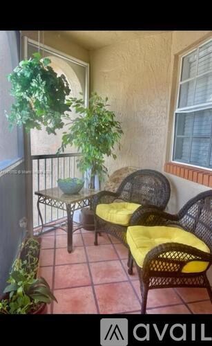 A patio with a table, chairs, and a potted plant.