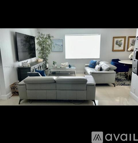 A living room with a white couch and a television.