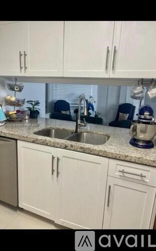 A kitchen with white cabinets and a granite countertop.