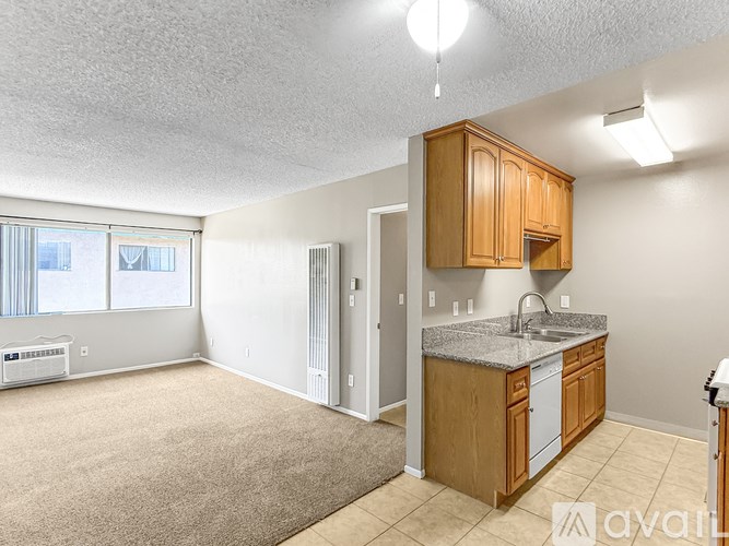 A kitchen area with wooden cabinets and a granite countertop.