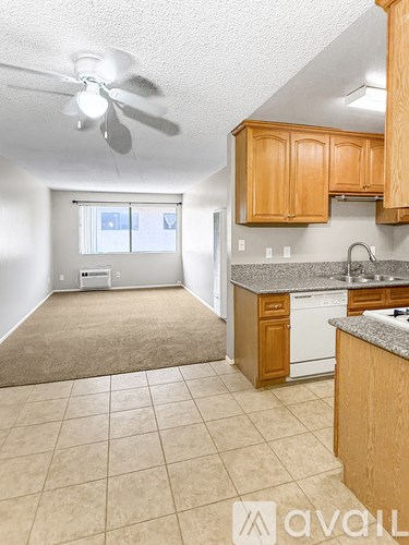 A kitchen with a white fridge and a fan on the ceiling.