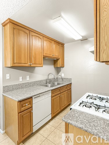 A kitchen with wooden cabinets and a granite countertop.