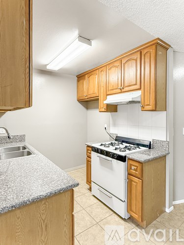 A kitchen with wooden cabinets and a granite countertop.