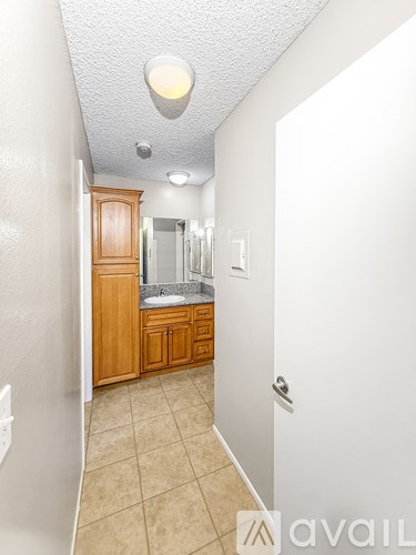 A bathroom with a wooden vanity and a white door.