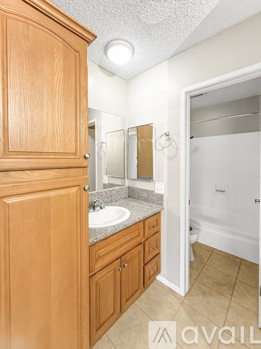 A bathroom with wooden cabinets and a white sink.
