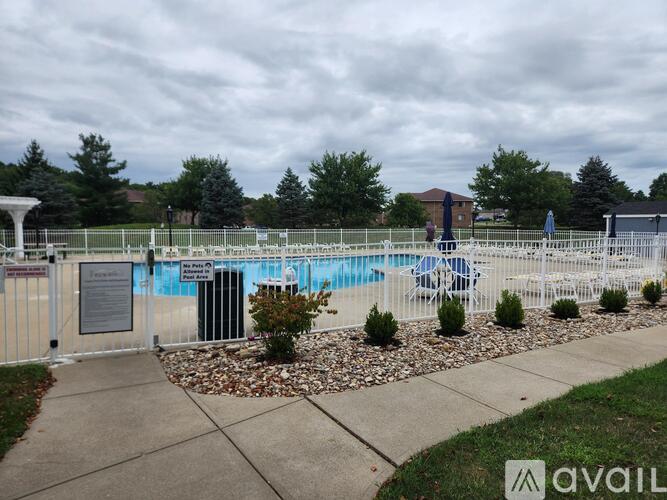 A pool surrounded by a white fence and a sign that says "AVAILABLE".