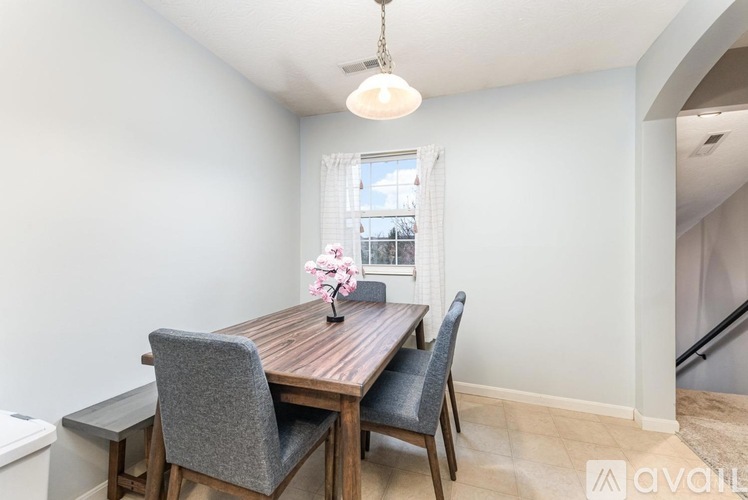 A dining room with a wooden table and grey chairs.