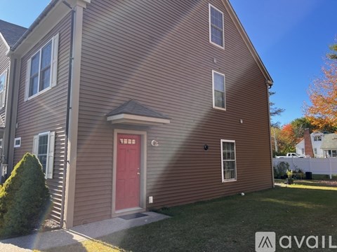 A house with a red door and a car parked in front.