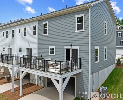 A two-story building with a balcony and a garage.