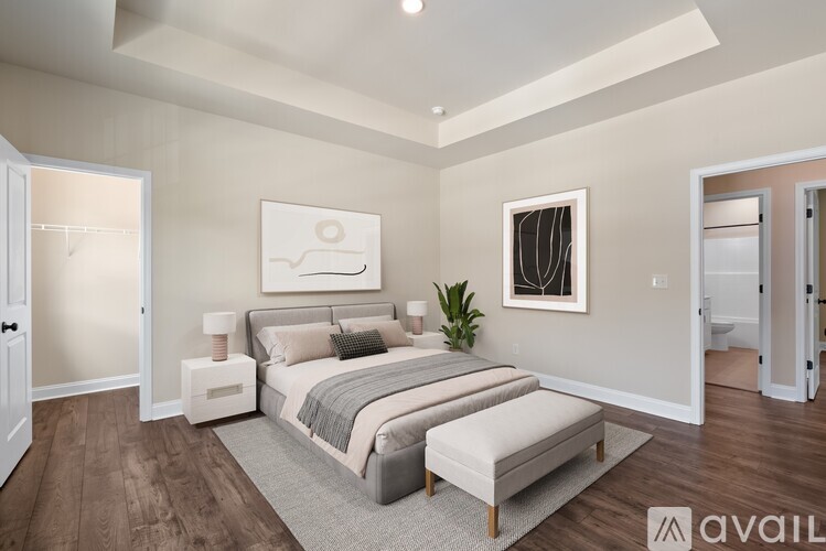 A bedroom with a large bed and a painting on the wall.