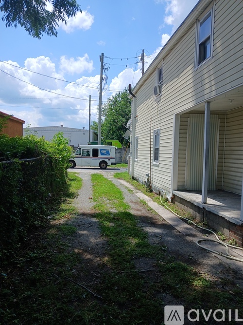 A white van is parked on a driveway in front of a house.