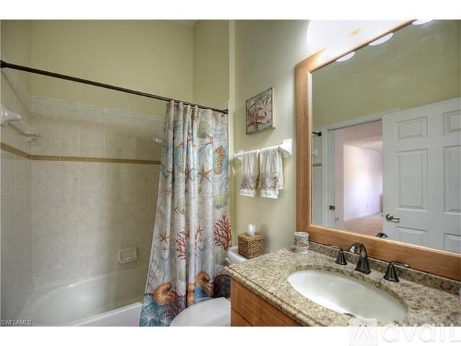 A bathroom with a white tub, sink, and a mirror.