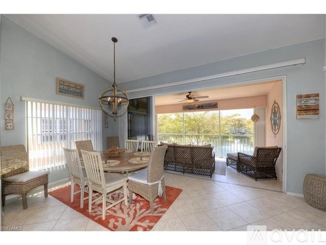 A dining room with a table set for six and a view of the outdoors.