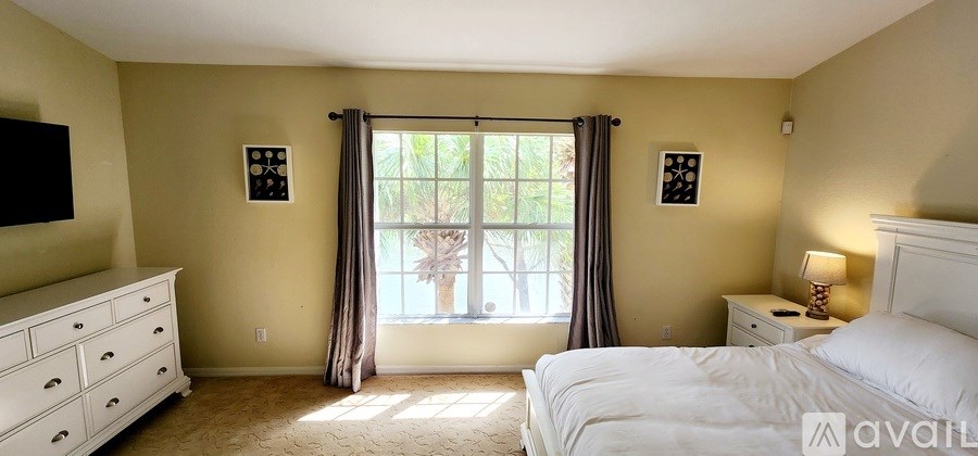 A room with a desk, chair, and a ceiling fan.
