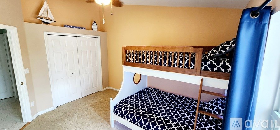 A bedroom with a bunk bed and a white wardrobe.