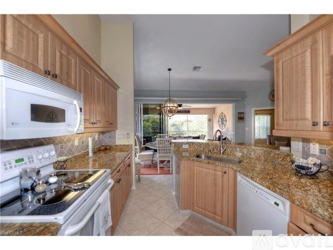 A kitchen with granite countertops and wooden cabinets.