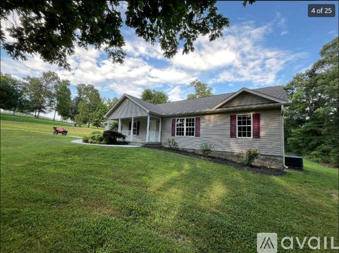 A house with a red window is surrounded by green grass.