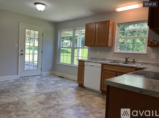 A kitchen with a white dishwasher and wooden cabinets.