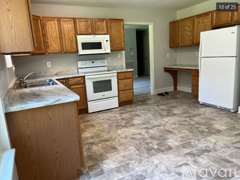 A kitchen with wooden cabinets and a white fridge.