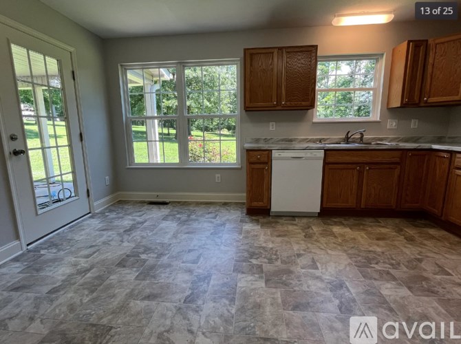 A kitchen with a tile floor and wooden cabinets.