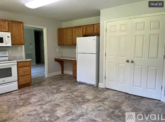 A kitchen with a white refrigerator and wooden cabinets.
