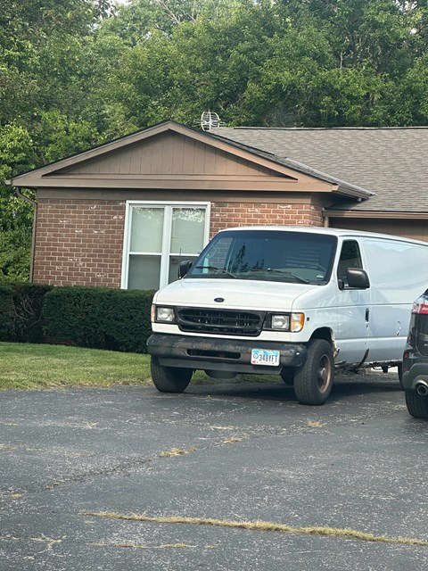 A white van is parked in a parking lot.