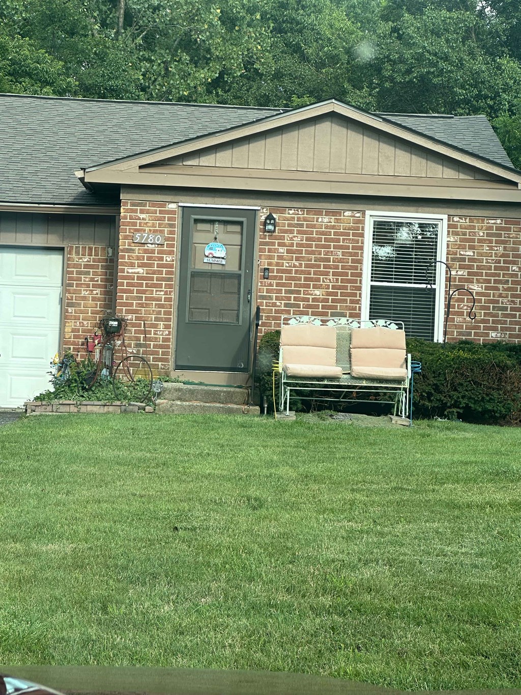 A house with a grey door and a brick wall.