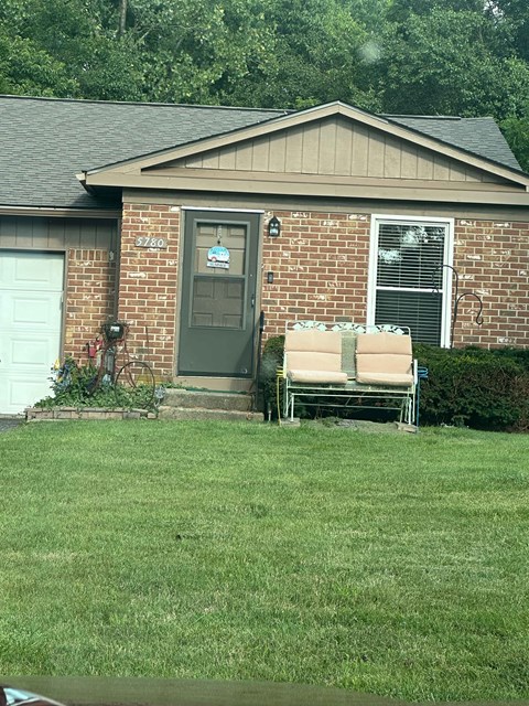 A house with a grey door and a brick wall.