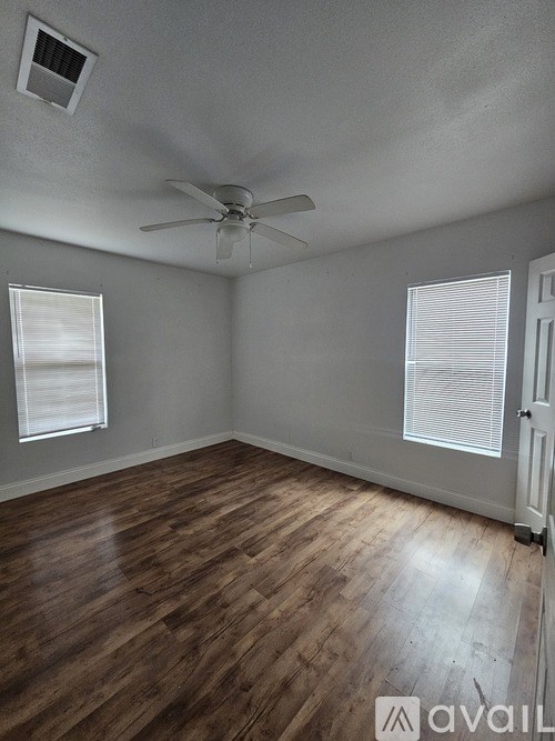 A room with wooden flooring and a ceiling fan.