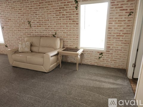 A living room with a beige couch and a small table.