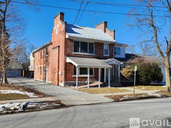 A red brick house with a white roof and a porch.