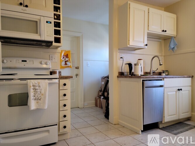 A kitchen with white appliances and cabinets.