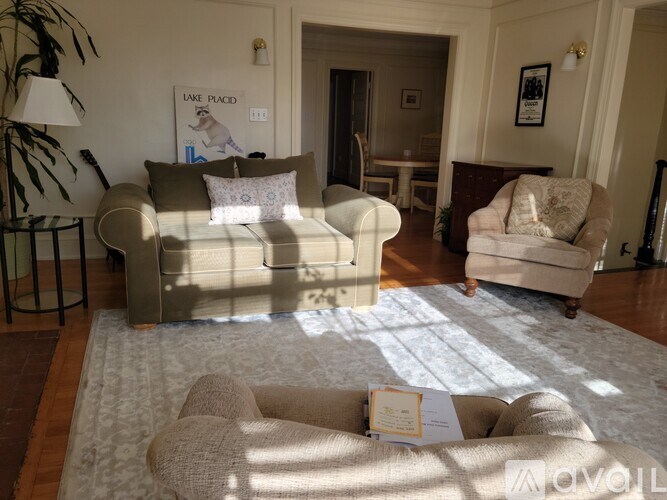 A living room with a beige couch and a white rug.