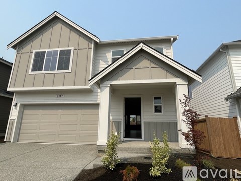 A two-story house with a garage and a driveway.