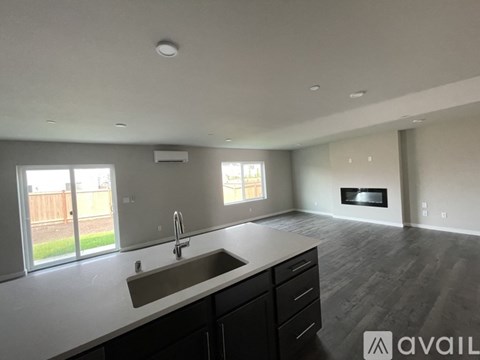 A modern kitchen with a sink, cabinets, and a window.