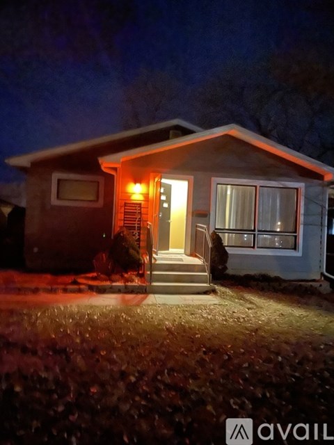 A house with a lit up front porch and steps.