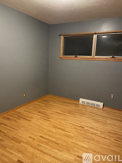 A room with wooden flooring and a window.