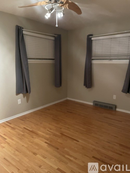 A room with wooden flooring and a ceiling fan.